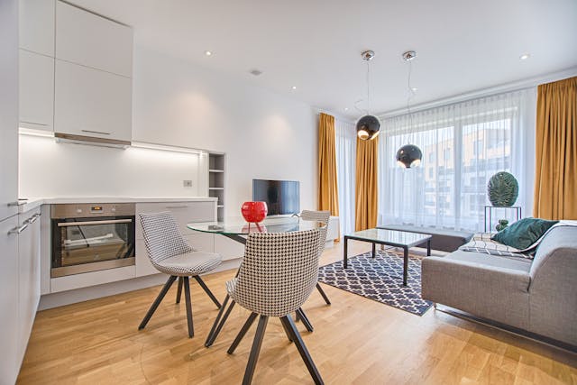 Furnished dining room and living room with a table, chairs, and couch.